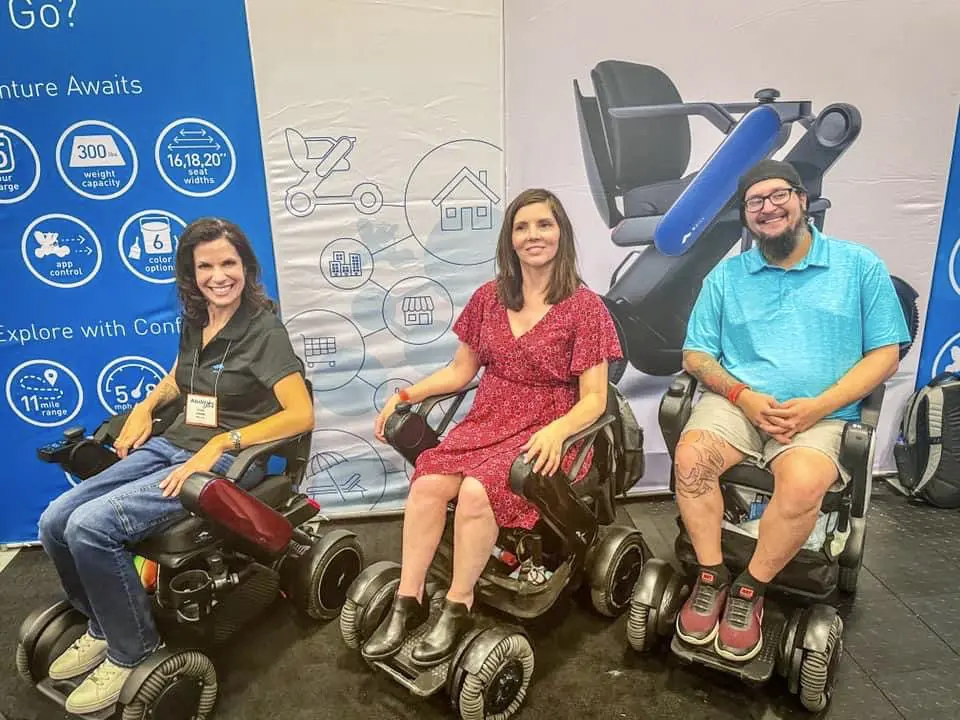 Three People Sat In New Tech Mobility Power Wheelchair