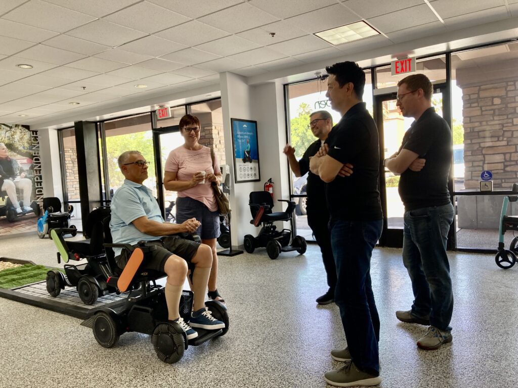 People In Discussion About New Tech Mobility Wheel Chair