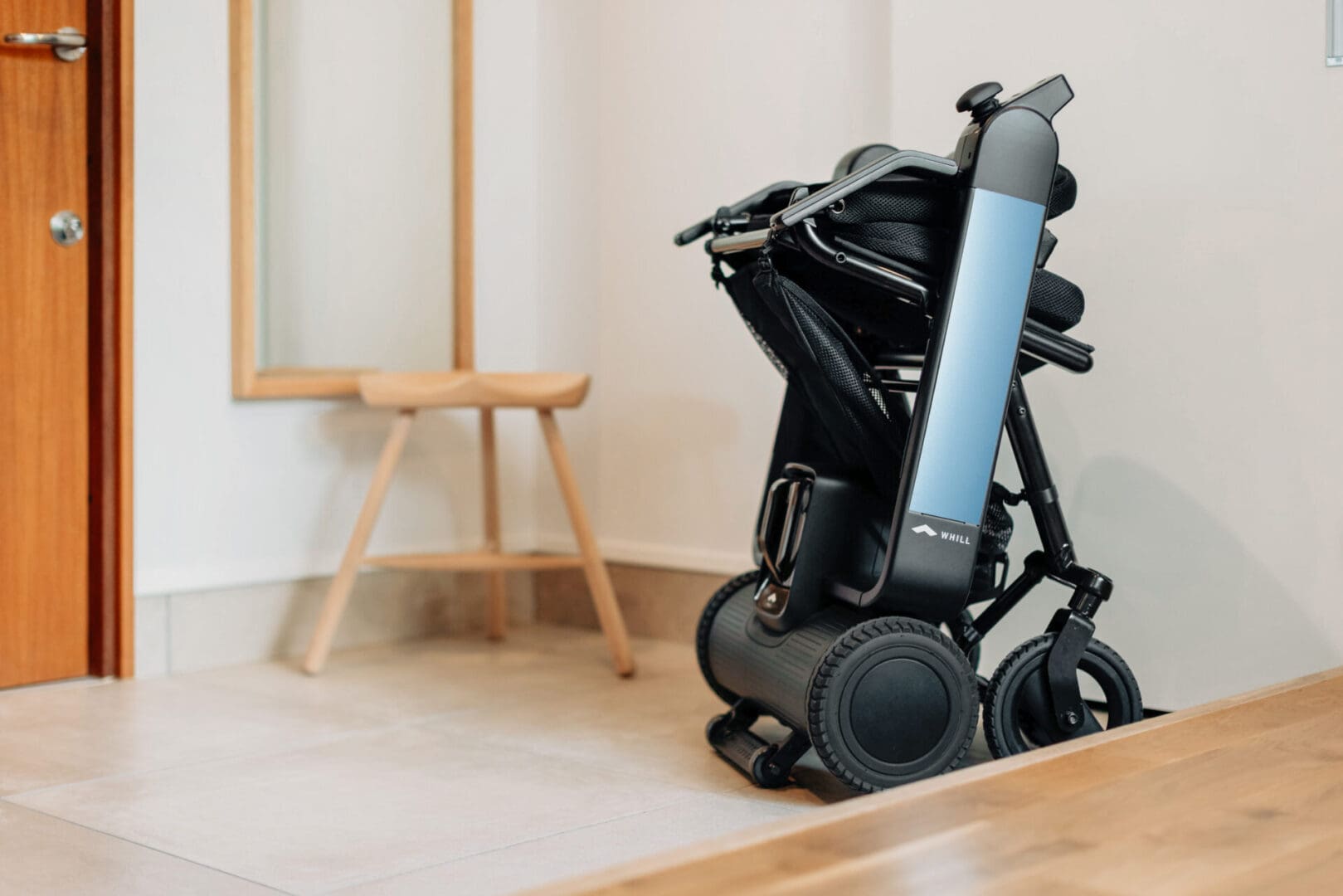 An electric scooter is sitting on the floor in front of a door.