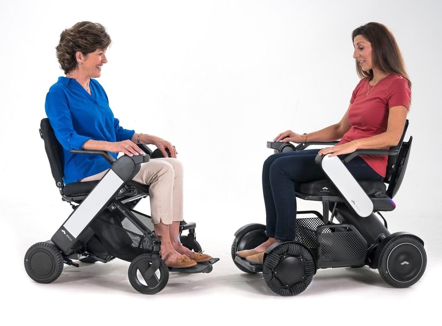 Two women sitting in a wheelchair on a white background.