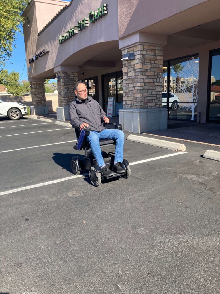 A man riding his wheel chair in the parking lot