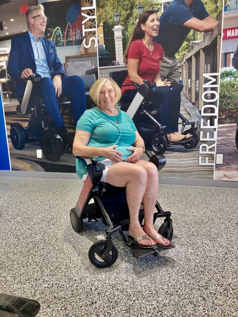 A woman sitting in a wheelchair in front of a poster.