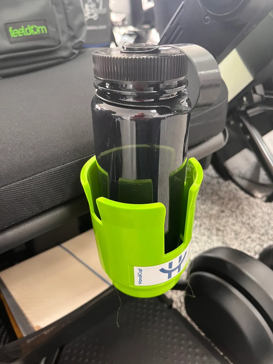 A green bottle holder on the seat of a car.