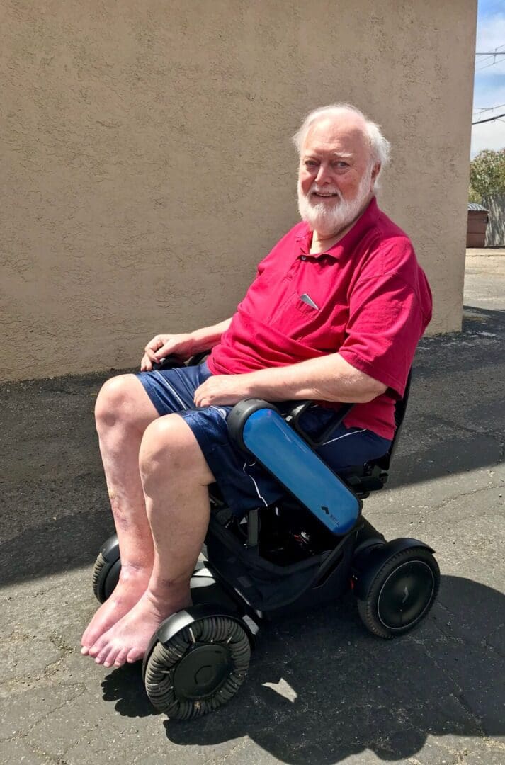 An older man sitting in a wheel chair.