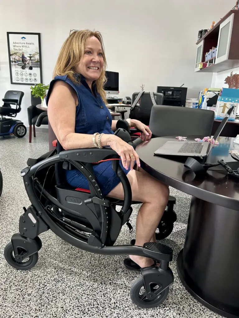 A woman using the WHILL Mobility Device in office