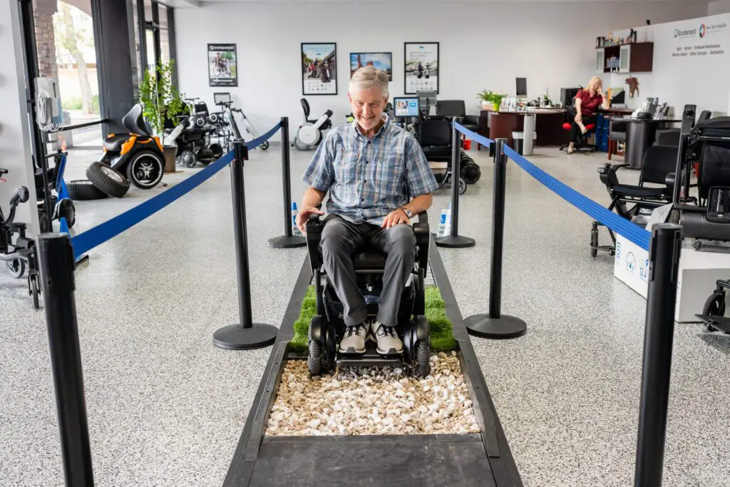 A senior man using the WHILL Mobility Device and smiling