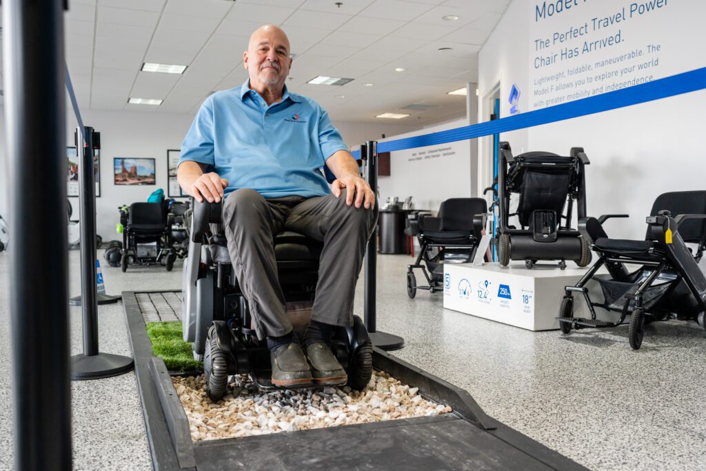 A person wearing a blue shirt using the WHILL Mobility Device