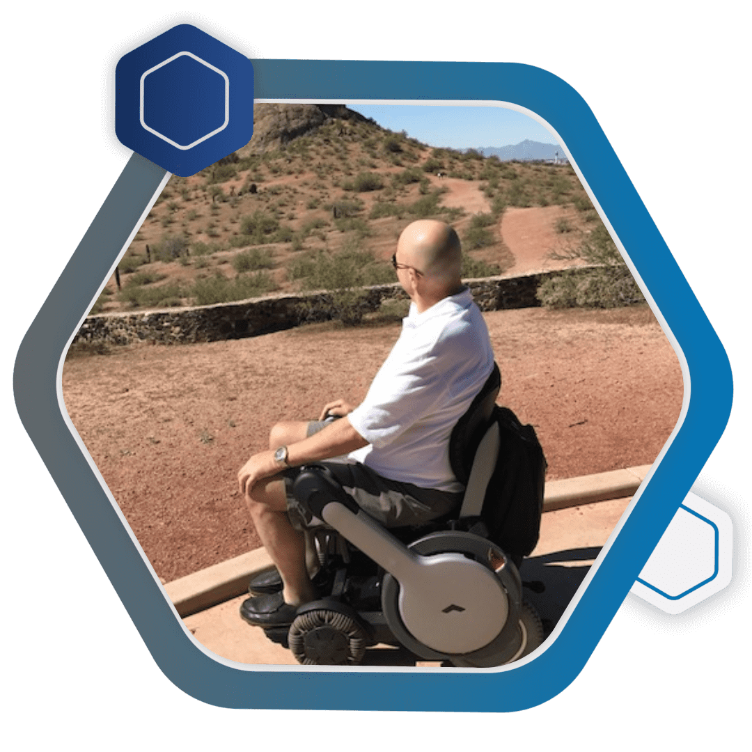 A man sitting in a wheel chair in the desert.