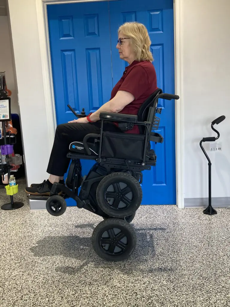 A woman sitting in a wheel chair in a garage.