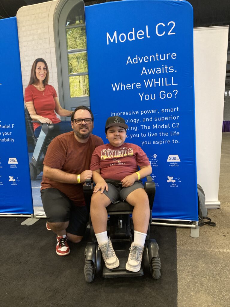 A man in a wheelchair and a boy in a wheelchair.