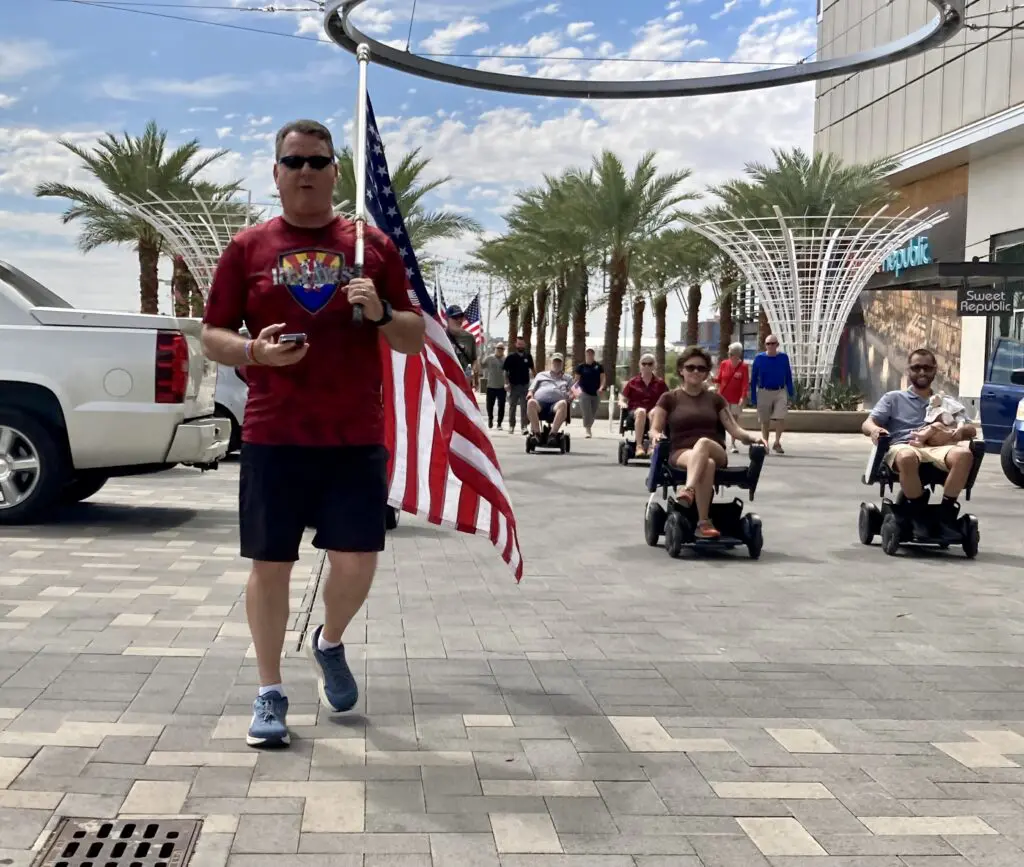 A man walking down the street with an american flag.