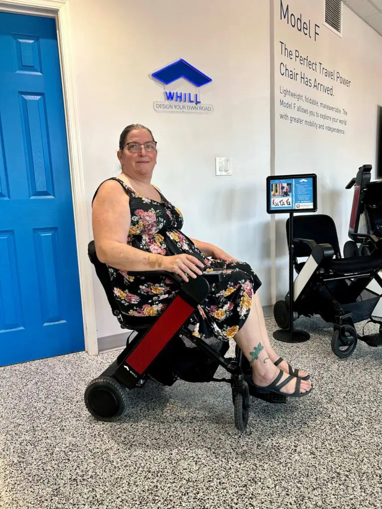 A woman sits in a wheelchair in a waiting room.