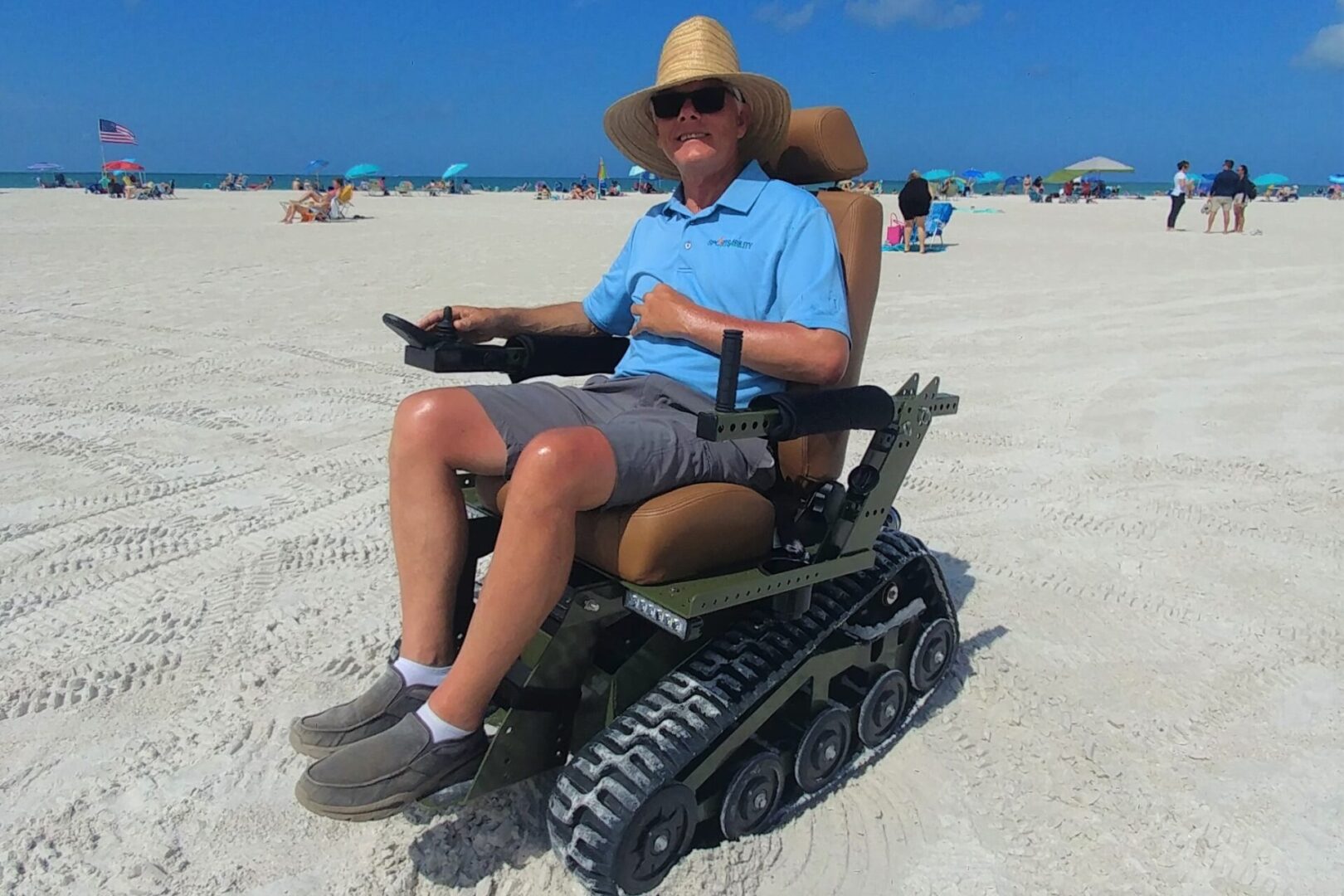 A man sitting in a wheelchair on the beach.