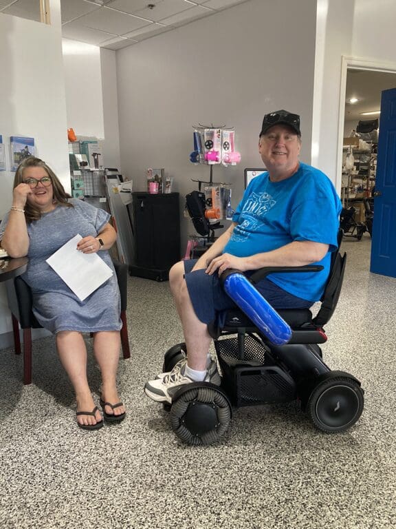 Man and woman in a wheelchair in a medical office.