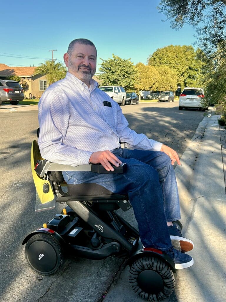 Man smiling in his XSTo power chair.