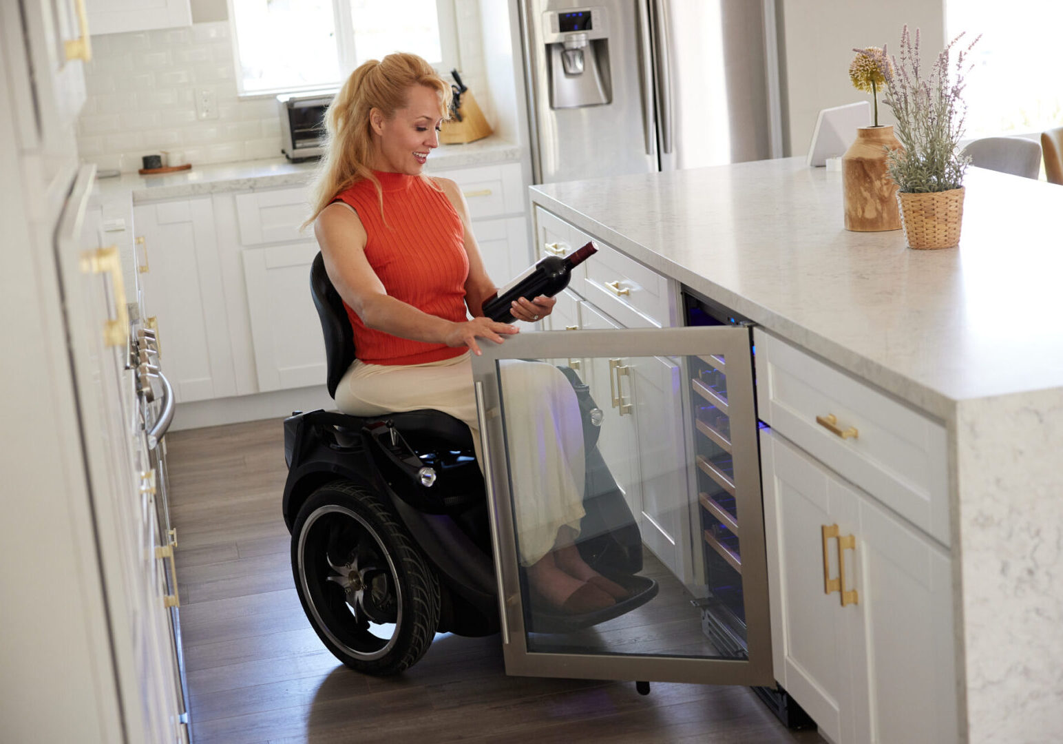 A woman sitting in a wheelchair in a kitchen.